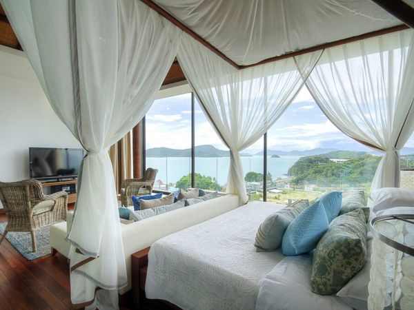 A luxurious hotel bedroom with a sea view.
